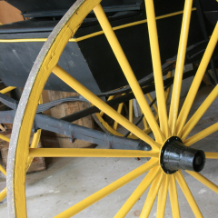 Yellow wagon wheel, Memory Lane Heritage Village, Museum in Lake Charlotte, Nova Scotia, Canada