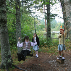 Kids on swing, Memory Lane Heritage Village, Museum in Lake Charlotte, Nova Scotia, Canada